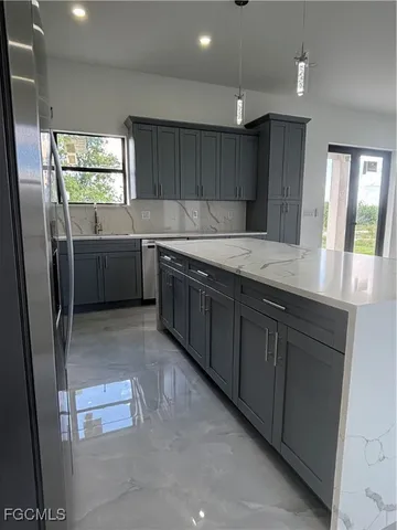 a kitchen with stainless steel appliances granite countertop a sink a stove a refrigerator a sink a window