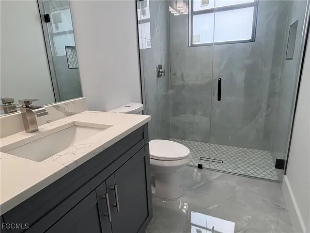 a bathroom with a sink a toilet and shower