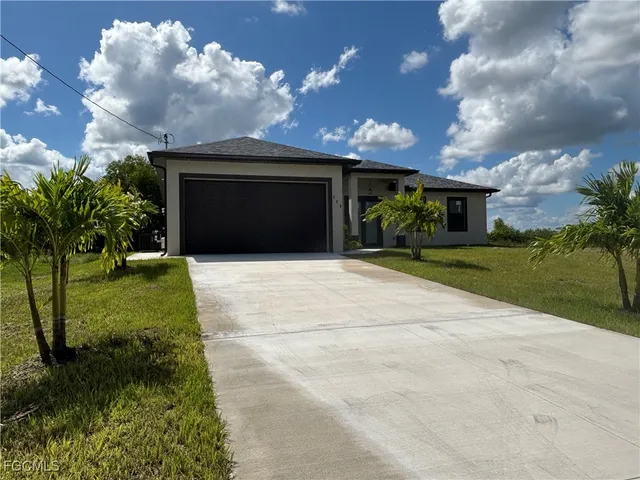 a front view of a house with a yard and garage
