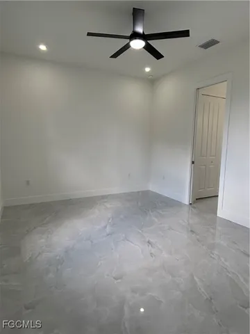 an empty room with a ceiling fan and a fan