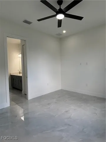 a view of an empty room with a chandelier fan
