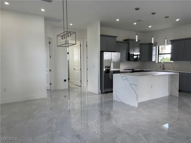 a kitchen with stainless steel appliances granite countertop a sink and a refrigerator