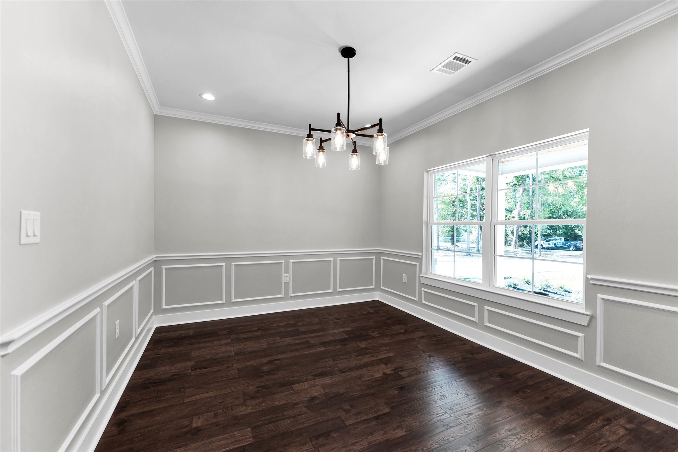 1087 Jones Road New Waverly, TX 77358 - Photo 3 of 44 Elegant dining room featuring rich hardwood floors and a stylish modern chandelier. Large window provides ample natural light.