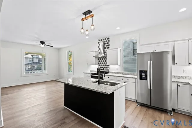 a kitchen with stainless steel appliances granite countertop a refrigerator and a sink