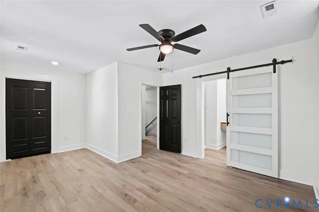 a view of a livingroom with a ceiling fan and wooden floor