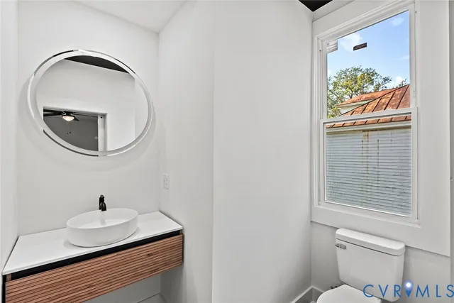 a bathroom with a toilet a sink and mirror