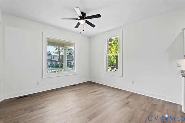 a view of room with window ceiling fan and hardwood floor