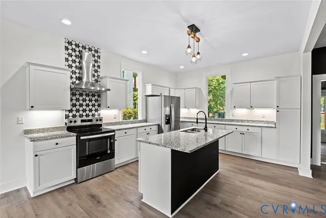 a kitchen with kitchen island stainless steel appliances a sink stove and refrigerator