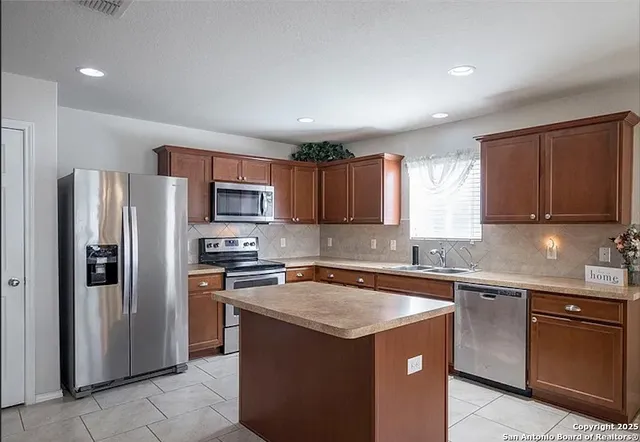 a kitchen with stainless steel appliances granite countertop a refrigerator stove a sink and dishwasher