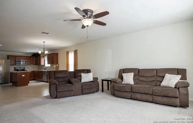 a living room with furniture and a ceiling fan