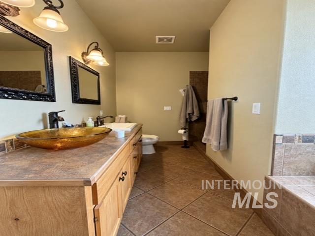 1520 Scheloske Road Weiser, ID 83672 - Photo 14 of 42 Stacked stone fireplace, tray ceiling with ceiling fan, two-panel interior door, and wall-to-wall carpeting