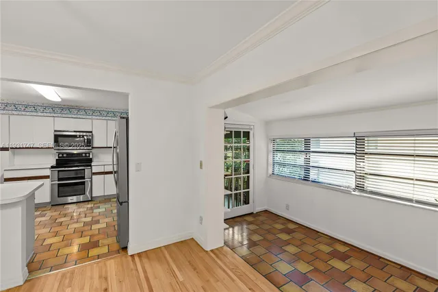 a view of a kitchen with wooden floor and electronic appliances