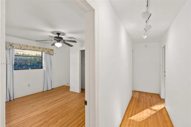 a bedroom with a bed and a chandelier fan
