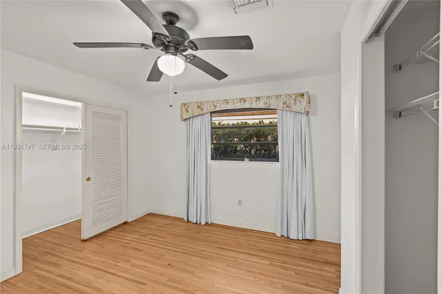 a view of empty room with wooden floor