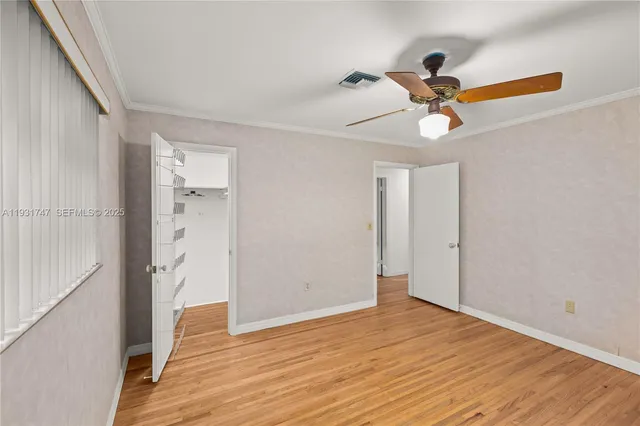 a view of a room with wooden floor and ceiling fan