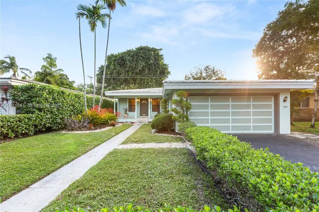 a view of a house with a big yard and potted plants