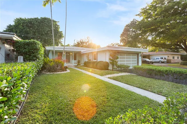 a view of a house with a yard and potted plants