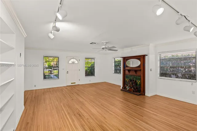 an empty room with windows and cabinet