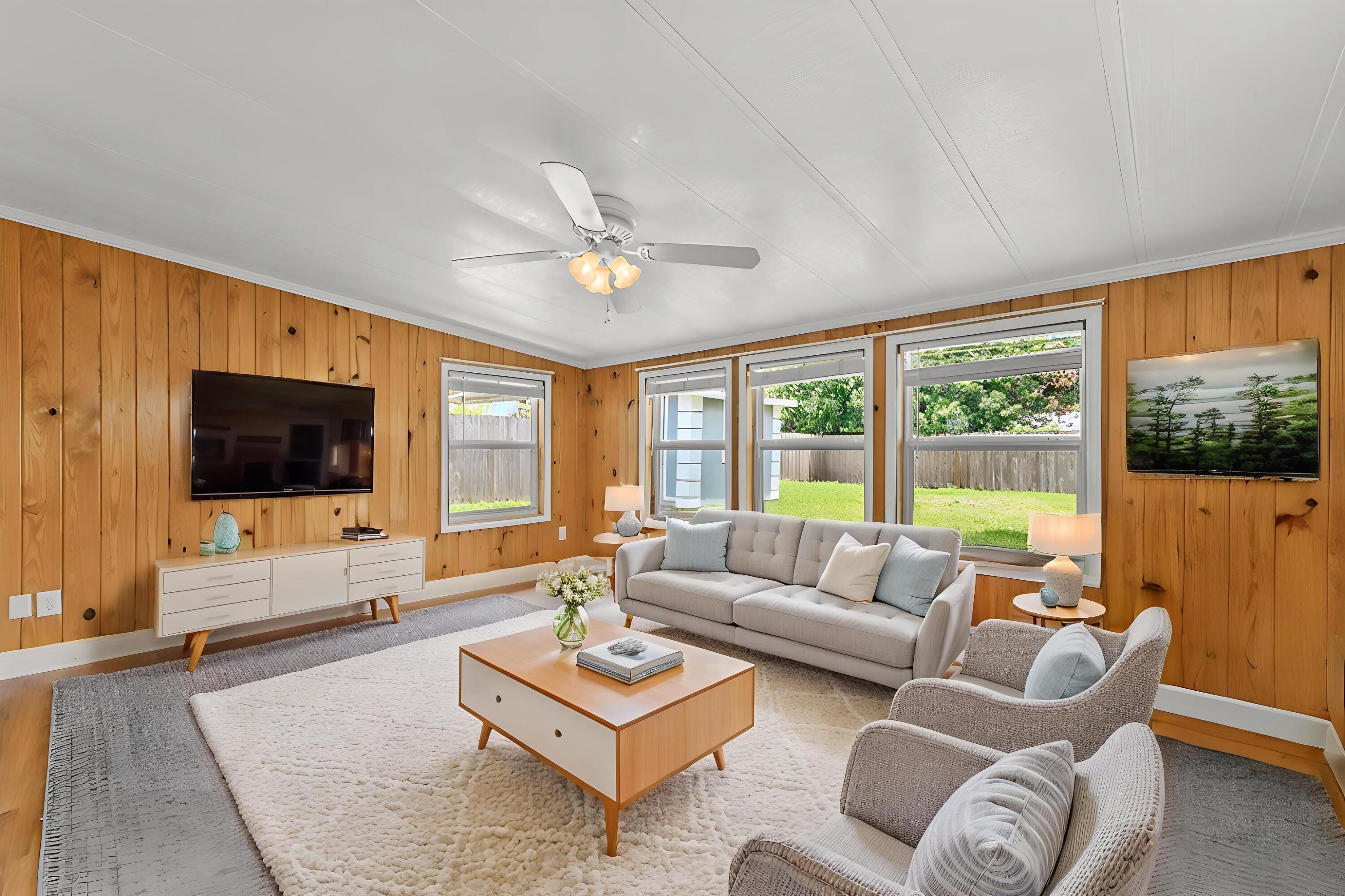 5709 Southeast Indigo Avenue Stuart, FL 34997 - Photo 13 of 26 a living room with furniture a flat screen tv and a large window