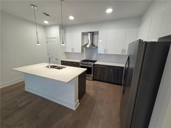 a kitchen with a sink a refrigerator a stove and cabinets