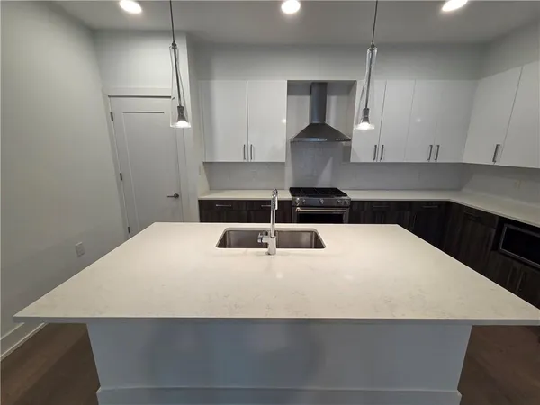 a kitchen with a sink a refrigerator and chairs