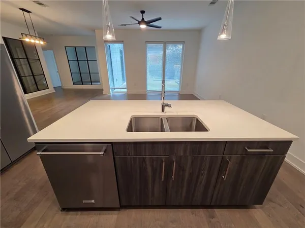 a kitchen with metallic refrigerator and a sink