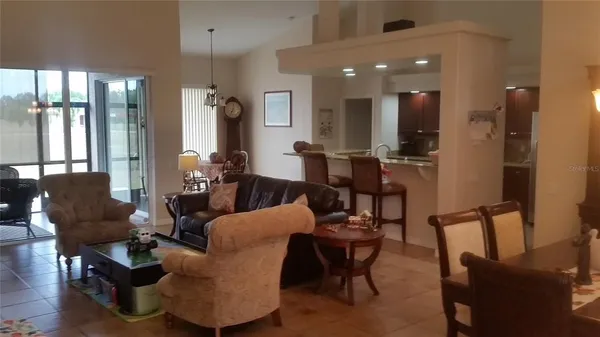 a living room with furniture and a dining table with wooden floor