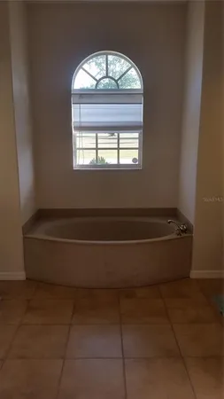 a spacious bathroom with a bathtub and a window