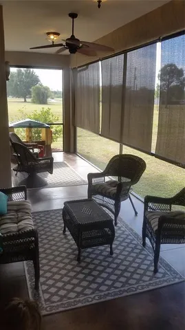a living room with furniture and a floor to ceiling window