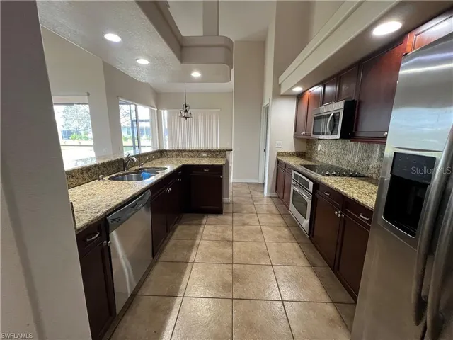 a kitchen with stainless steel appliances granite countertop a sink stove and oven