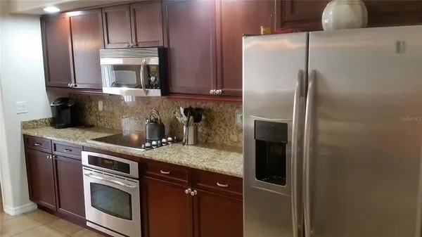 a kitchen with stainless steel appliances granite countertop a refrigerator and a sink