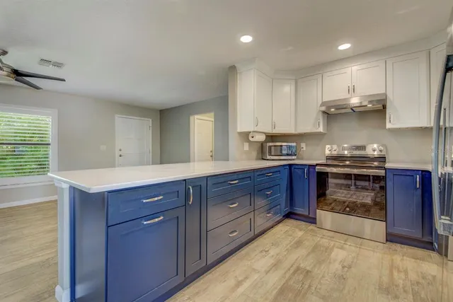 a kitchen with stainless steel appliances granite countertop a stove a sink dishwasher and a refrigerator