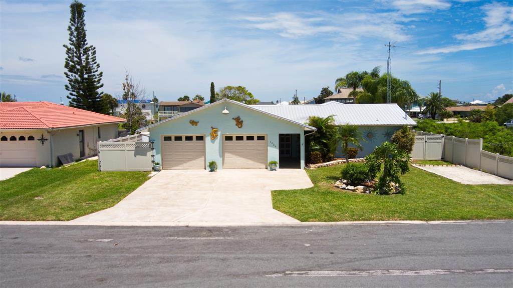 4266 Deleon Drive Hernando Beach, FL 34607 - Photo 65 of 65 a front view of a house with a yard and garage