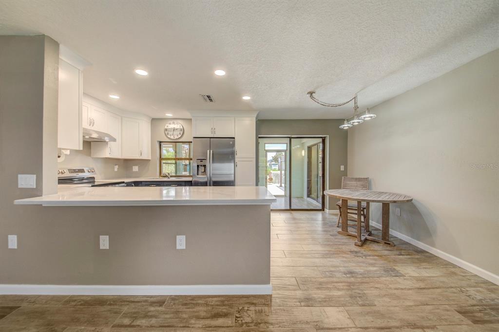 4266 Deleon Drive Hernando Beach, FL 34607 - Photo 10 of 65 a living room with stainless steel appliances granite countertop wooden floor a large window and a counter top space