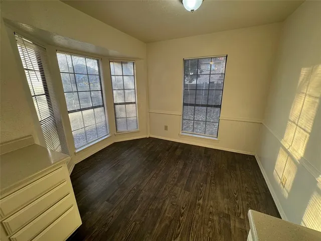 a kitchen with stainless steel appliances granite countertop a refrigerator a sink dishwasher a stove and white countertops with wooden floor