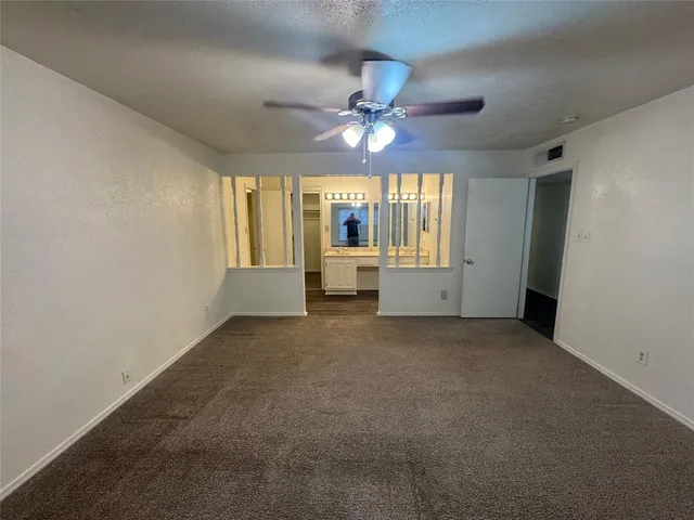 a spacious bedroom with a bed and a flat screen tv