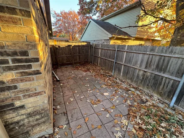 a view of backyard with wooden fence and large trees