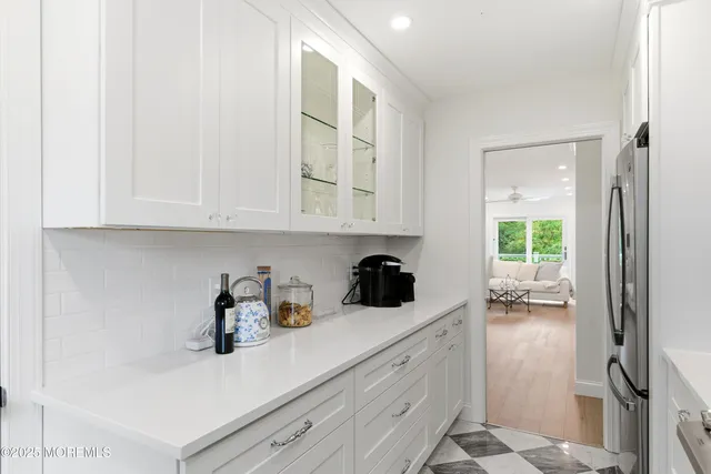 a kitchen with stainless steel appliances white cabinets and a window
