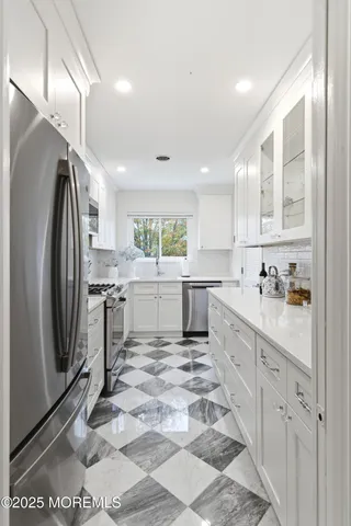 a kitchen with white cabinets and sink