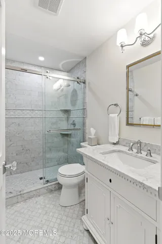 a bathroom with a granite countertop sink toilet and shower