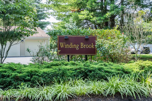 a sign that is sitting in front of a tree