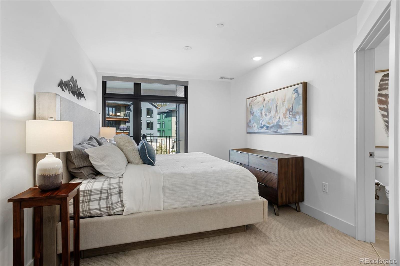 144 Ski Idlewild Road, Unit 3201 Winter Park, CO 80482 - Photo 18 of 39 a bedroom with a large bed and a lamp