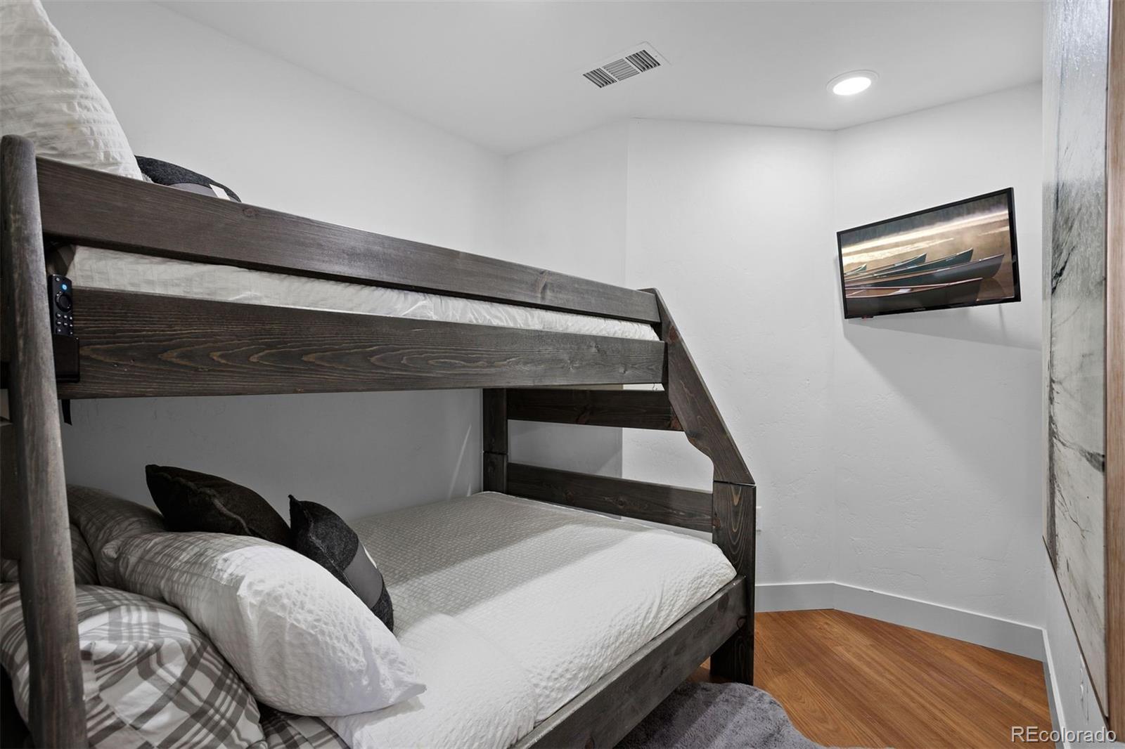 144 Ski Idlewild Road, Unit 3201 Winter Park, CO 80482 - Photo 26 of 39 a bedroom with bed and wooden floor