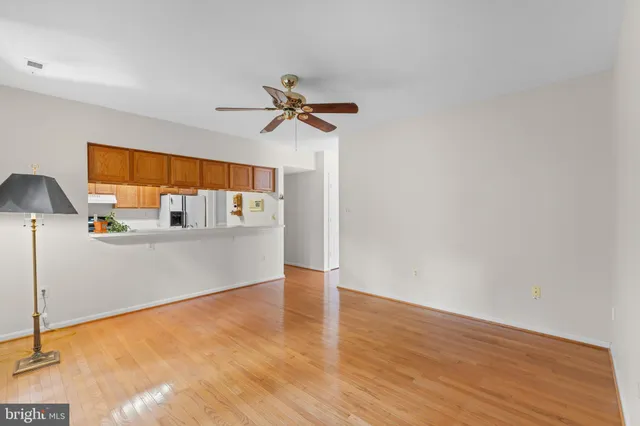 a view of a kitchen with wooden floor and a ceiling fan