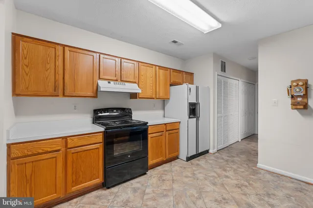 a kitchen with stainless steel appliances granite countertop a refrigerator stove and sink