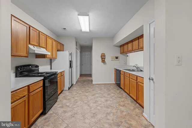 a large kitchen with stainless steel appliances granite countertop a stove and a refrigerator