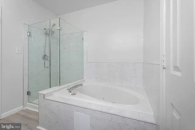 a white bath tub sitting next to a shower