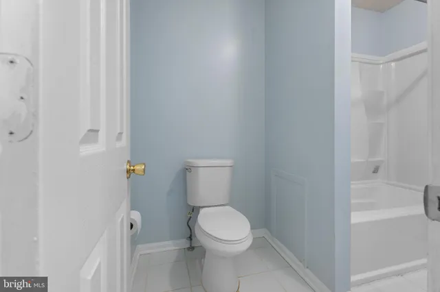 a white toilet sitting next to a bath tub