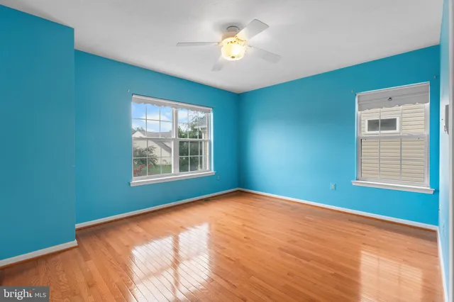 a view of an empty room with a window and a ceiling fan