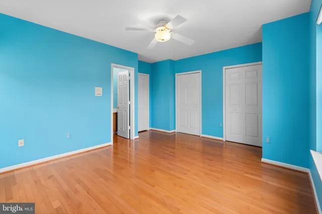 a view of an empty room with window and a ceiling fan